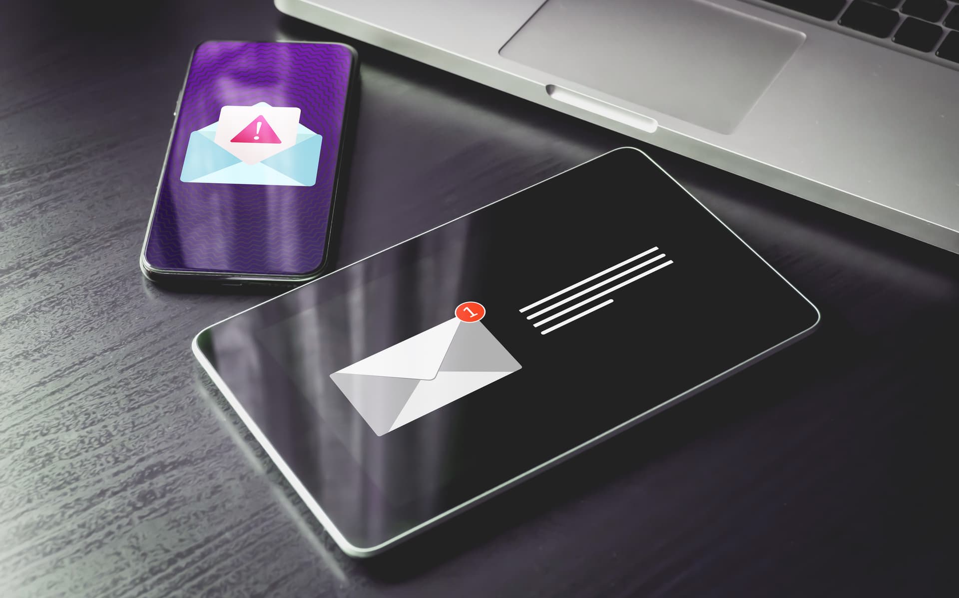 A person reading email on a laptop, where a contextual security banner is the only thing standing between them and a convincing-looking phishing invoice.